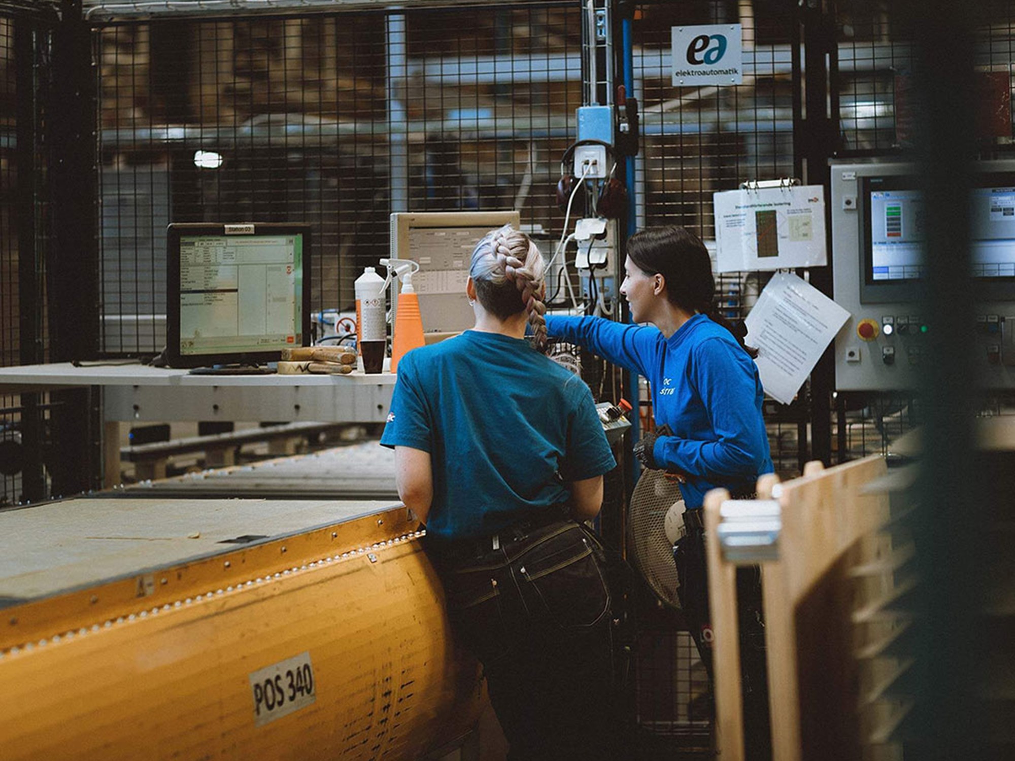 Två personer diskuterar i fabrik