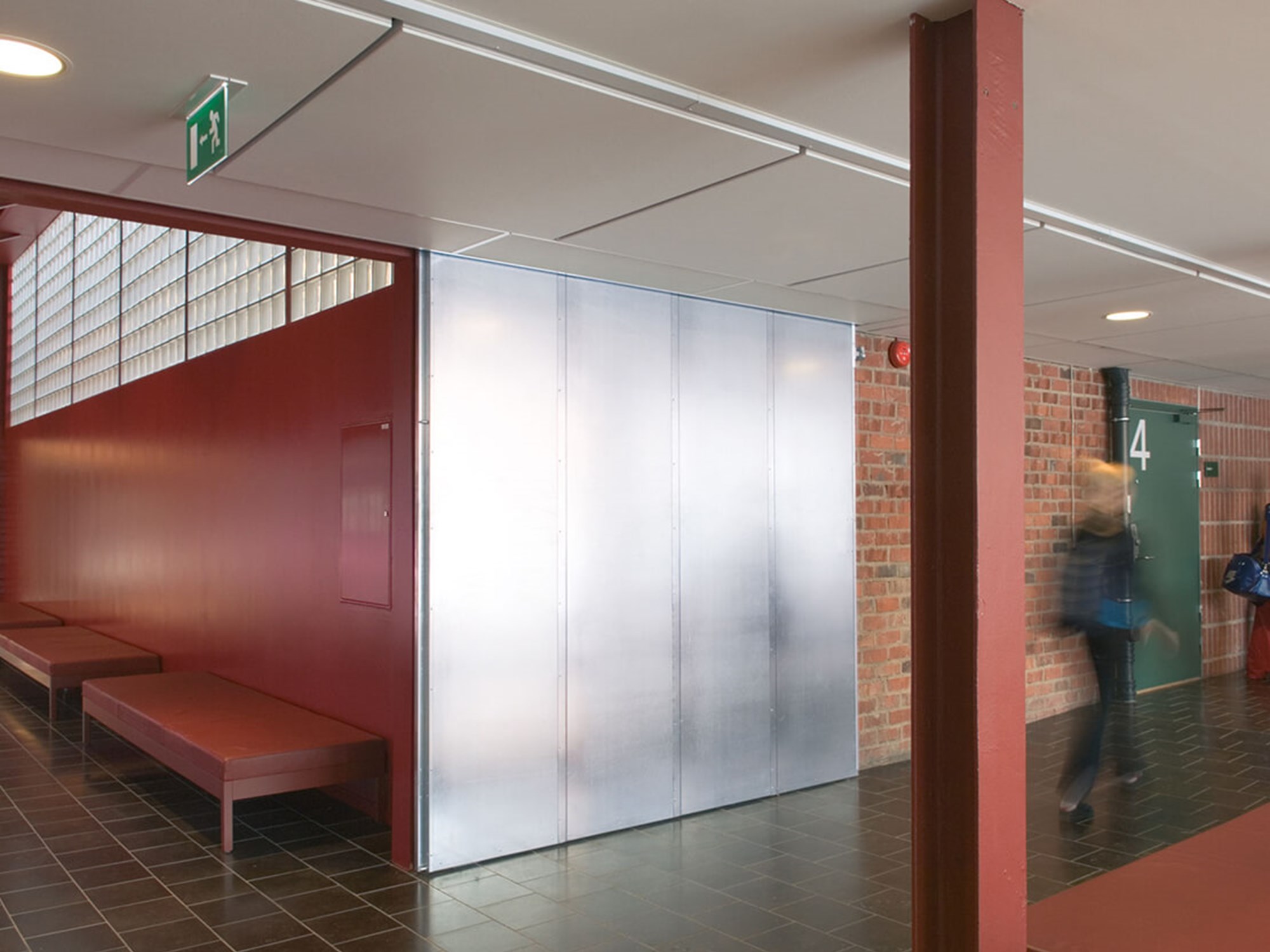 Skolkorridor med tegelvägg och rödmålad vägg